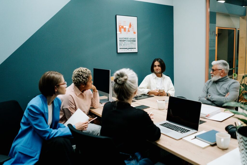 A diverse group of professionals engaged in a dynamic meeting in a modern office environment.
